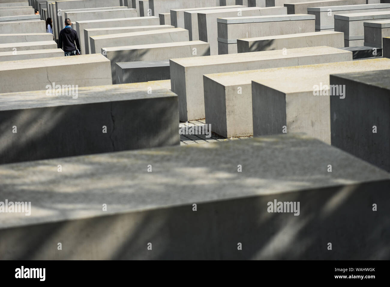 Die Besucher gehen durch Hunderte von betonplatten oder Der telae "Teil des Denkmals für die ermordeten Juden Europas "Holocaust Mahnmal" südlich des Brandenburger Tors. Holocaust Mahnmal wurde von amerikanischen Architekten Peter Eisenman entworfen, auf einer Fläche von 19.000 Quadratmetern von 2711 Betonplatten abgedeckt oder telae'. Stockfoto