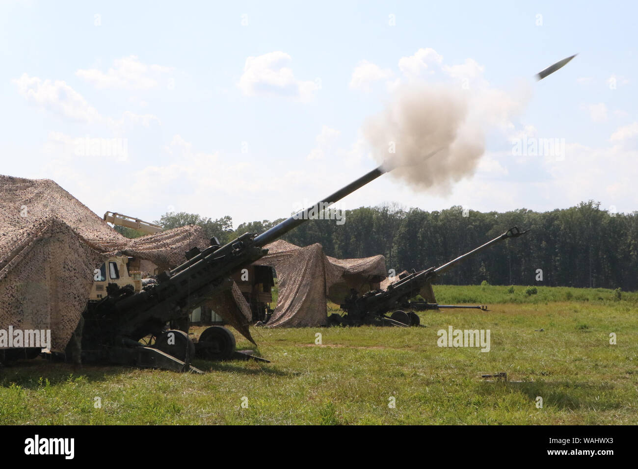 Virginia National Guard Soldaten zu den Hampton zugewiesene Charlie Batterie, 1.BATAILLON, 111 Field Artillery Regiment, 116 Infantry Brigade Combat Team live Fire M777A2 155mm Haubitzen Juli 28, 2019 während der Exportierbaren Kampftraining Fähigkeit Rotation 19-4 am Fort Pickett, Virginia. (U.S. Nationalgarde Foto von Baumwolle Puryear) Stockfoto