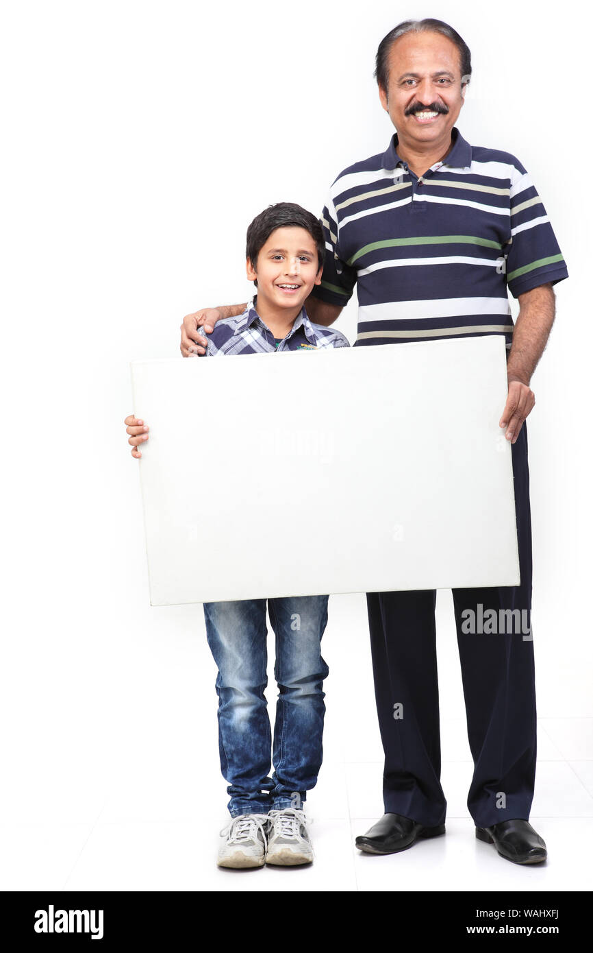 Alter Mann mit seinem Enkel, der ein leeres Plakat zeigt Stockfoto
