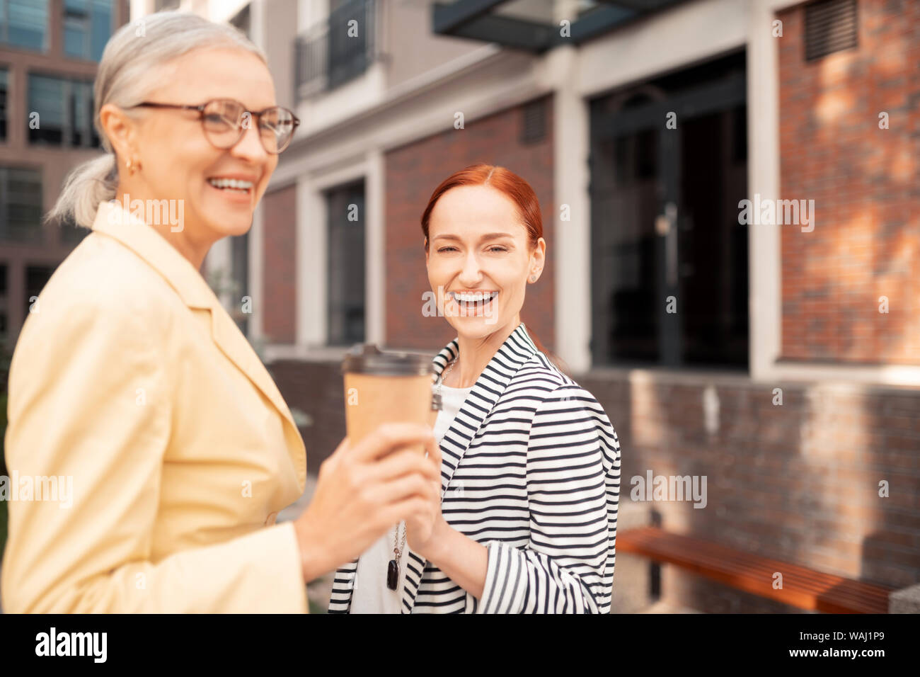 Frauen vor einem Bürogebäude lachen Stockfoto