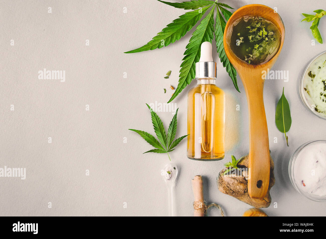 Glas Flasche und Dropper CBD ÖL, THC Tinktur und Cannabis Blatt auf Hintergrund. Labor Herstellung von Kosmetika mit CBD Öl. Stockfoto