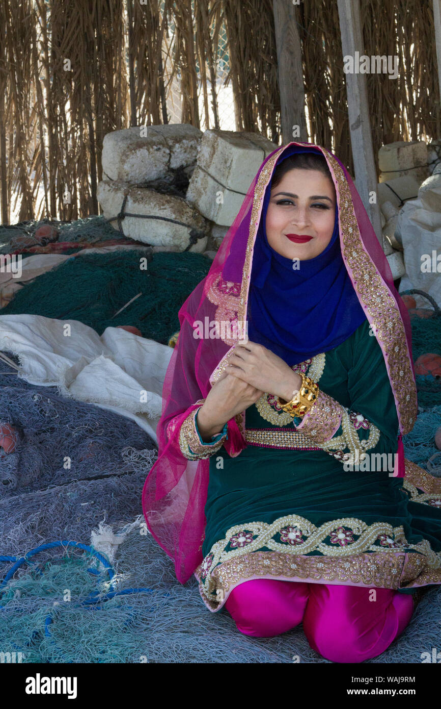 Arabische Frau im traditionellen und farbenfrohen Kleid. Qantab Fischerdorf. Al Bilad, Oman. (MR) Stockfoto