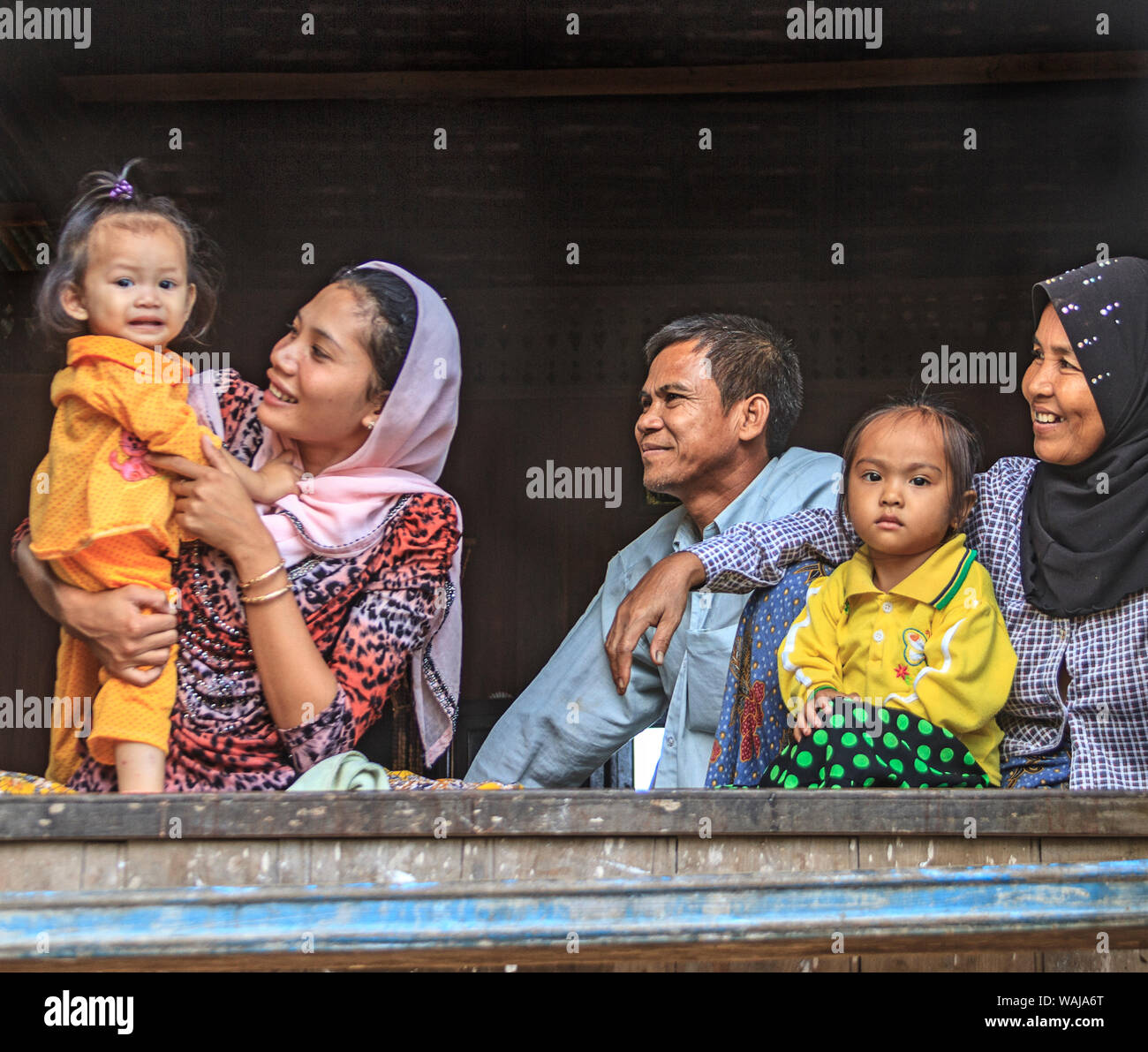 Kratie, Kambodscha. Junge Cham Frauen, Menschen und ihre jungen Kinder Rest in der Tür eines Hauses in einem Dorf auf dem Mekong Fluss. Die Cham sind die größte ethnische Minderheit in Kambodscha und sind meist muslimischen. (Redaktionelle nur verwenden) Stockfoto
