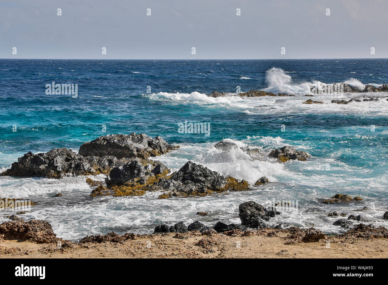 West Indies, Karibik, Aruba. Andicuri Strand, Wellen als die Flut unter den Felsformationen kommen Stockfoto