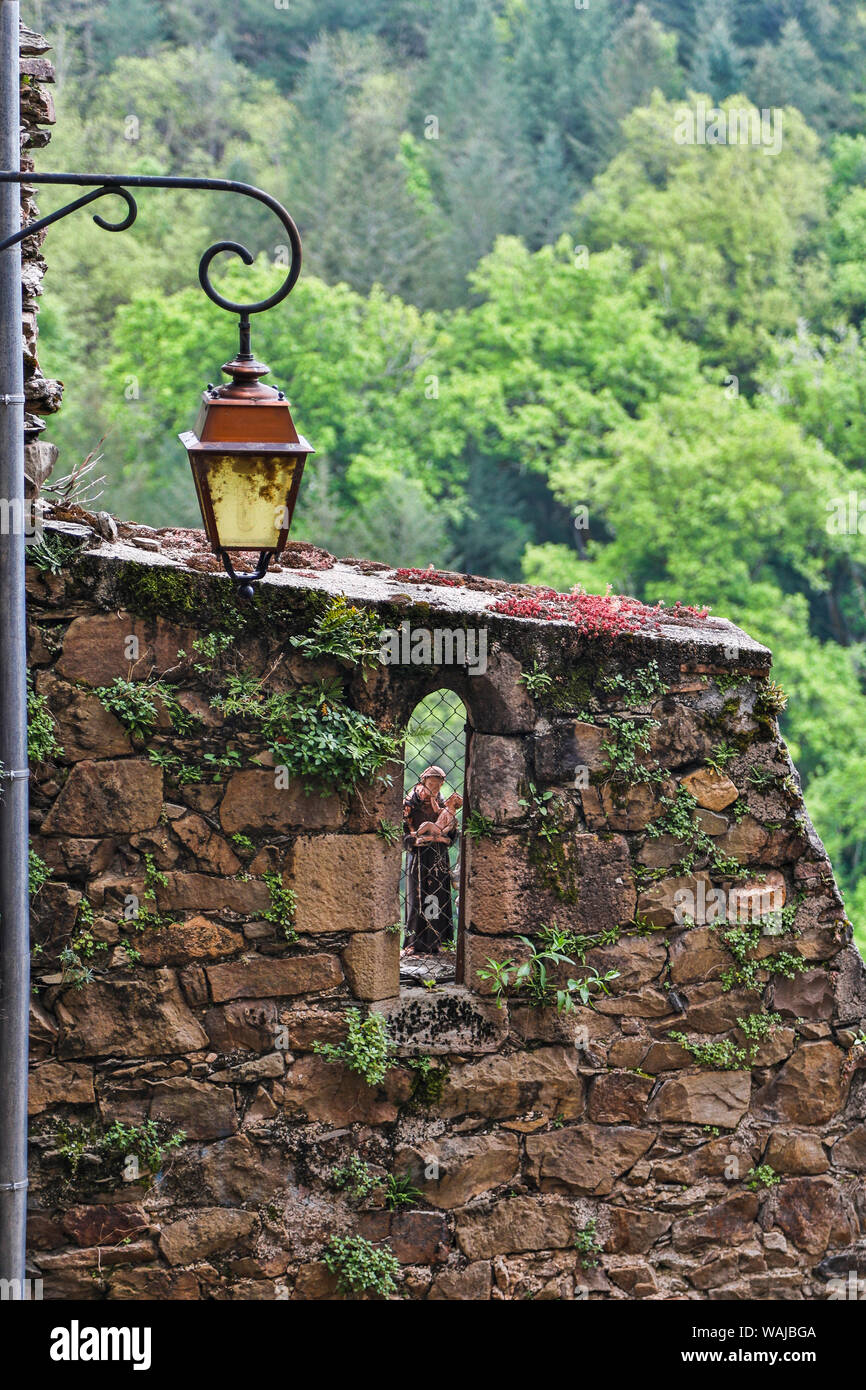 Frankreich, Najac. Steinmauer mit Statue und Lampe Stockfoto