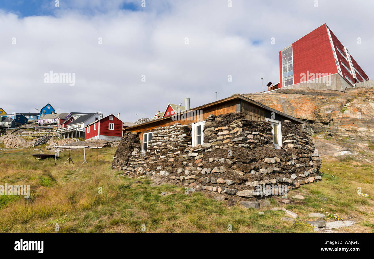 Traditionelles Haus, Mauern aus trockenem Stein und beat Isolierung, jetzt Teil der örtlichen Museum. Neue Schule in den Hintergrund. Kleine Stadt von Uummannaq, Nordwesten Grönlands. (Redaktionelle nur verwenden) Stockfoto
