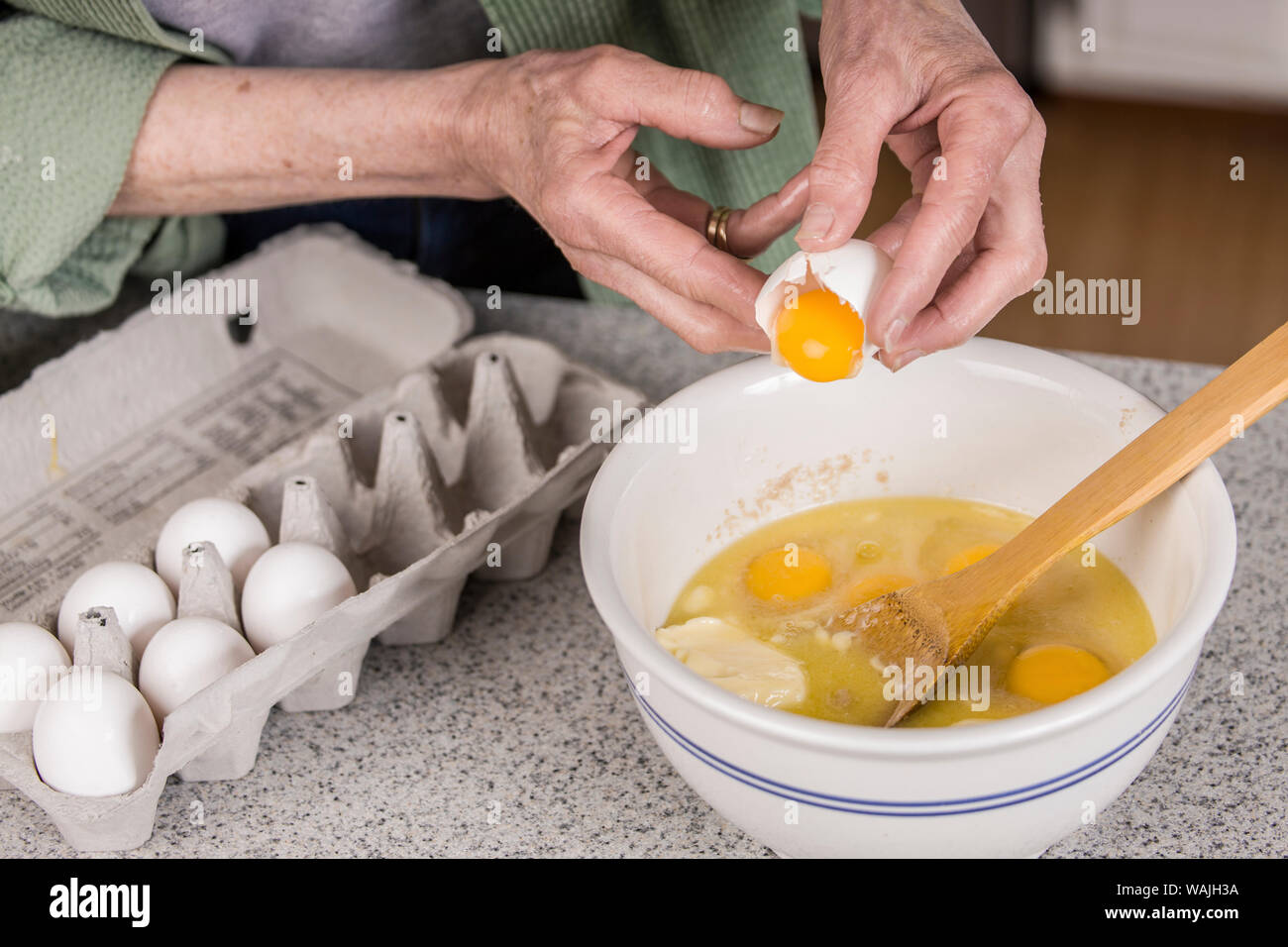 Frau brechen ein Ei, nur das Eigelb hinzufügen. Die sonstigen Bestandteile des Affen Brot. (MR) Stockfoto