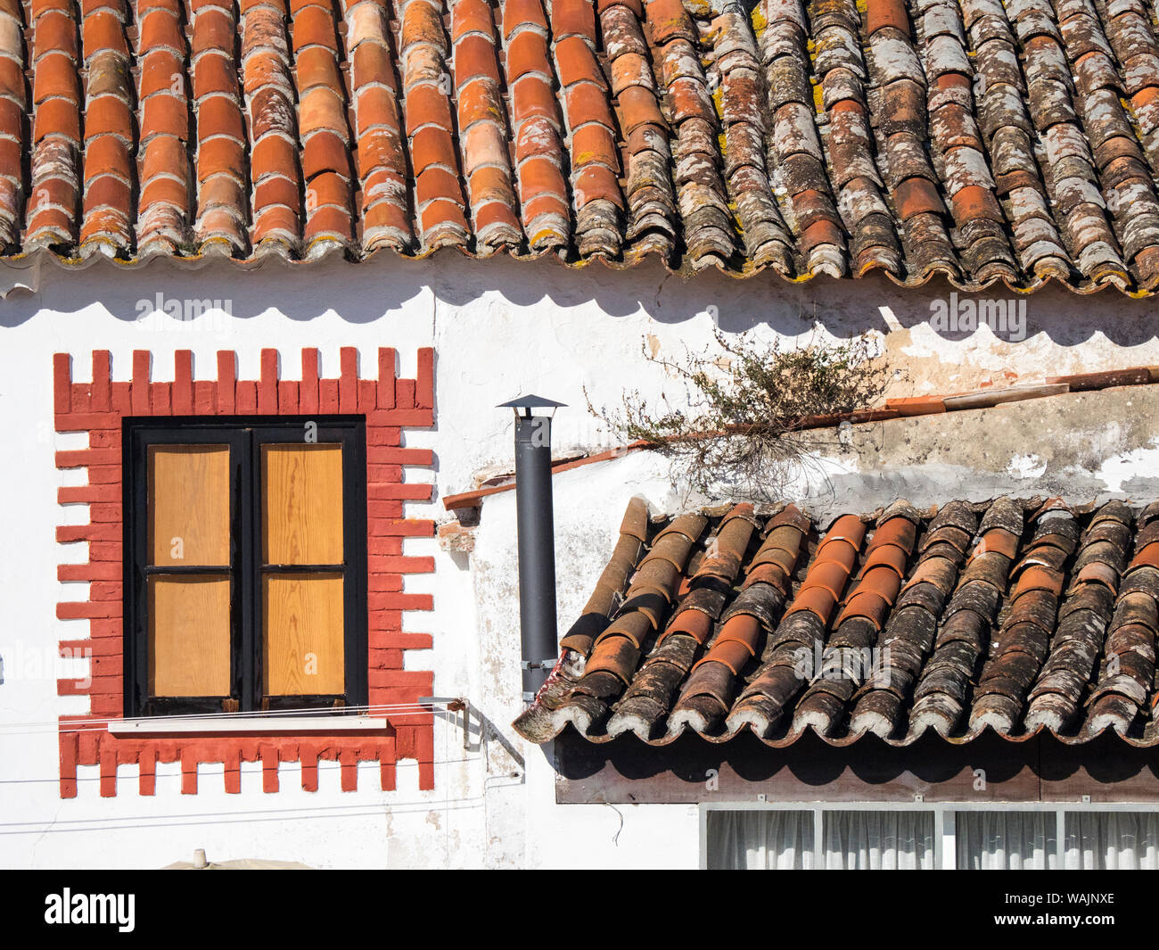 Portugal, Obidos. Ungewöhnlich dekorierte Fenster und Terrakotta Fliesen- Dach in der Nähe von Obidos. Stockfoto