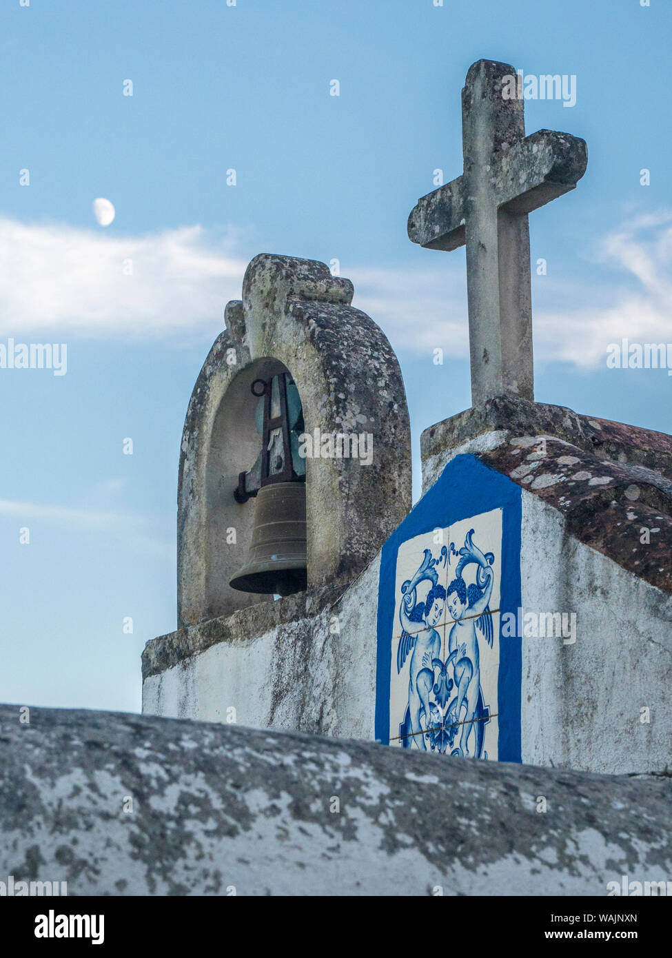 Portugal, Obidos. Glockenturm und Kreuz auf der Spitze einer Kirche in den Abend in der ummauerten Stadt Obidos. Stockfoto