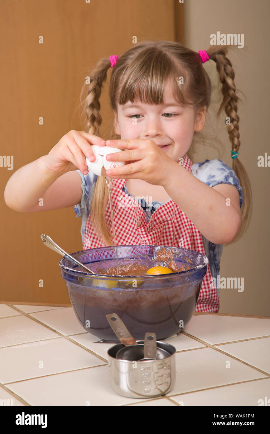 Mädchen, das Ei in eine Schüssel geben, eine Schokolade bundt Cake später zu werden. (MR, PR) Stockfoto