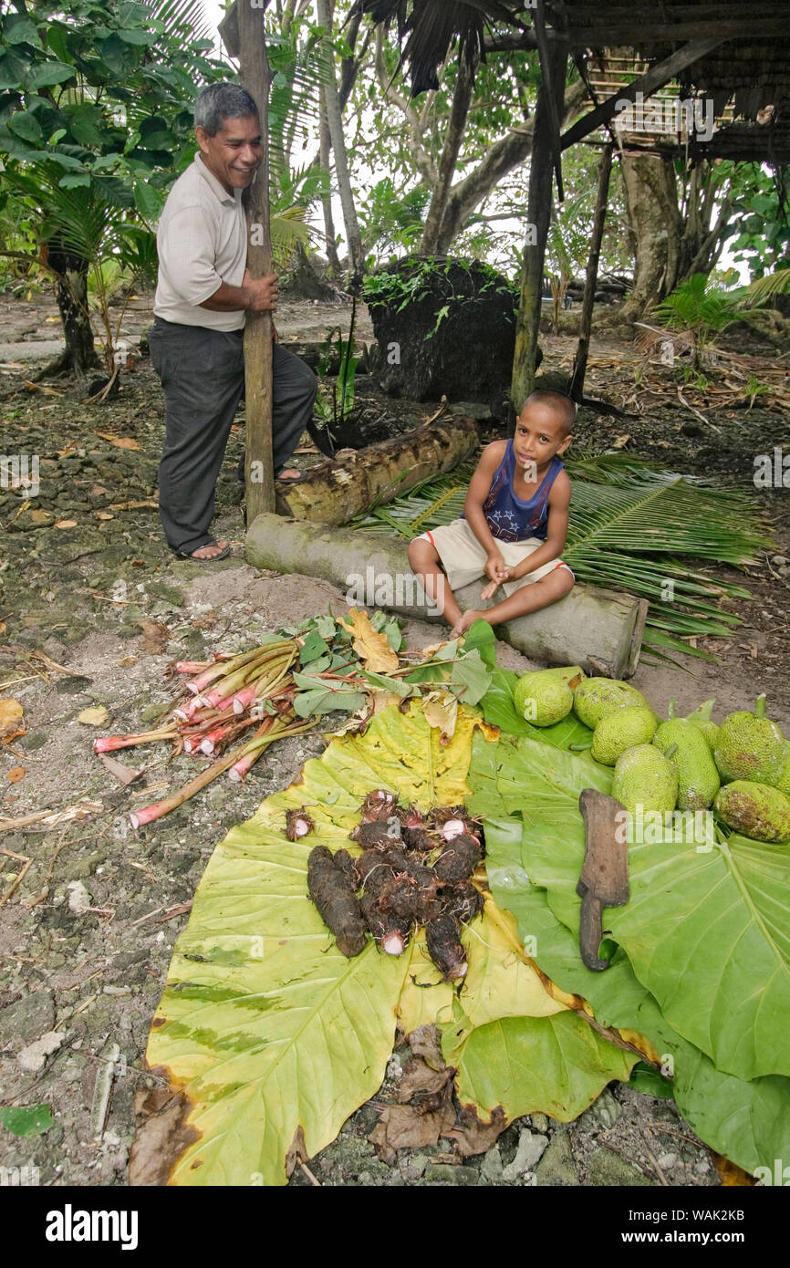 Kosrae, Mikronesien (FSM). Lokale Kosrae Mann und sein Sohn an einer traditionellen Grube Backofen (um). Hier, Taro Wurzeln und Brotfrucht erwarten Kochen während der Fisch gart unter den Blättern. (Redaktionelle nur verwenden) Stockfoto