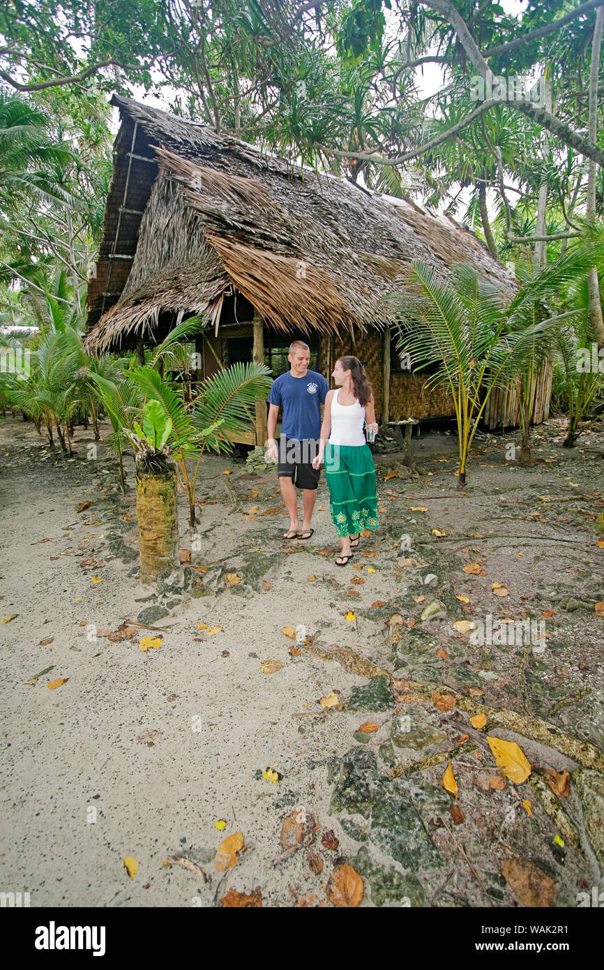 Kosrae, Mikronesien (FSM). Junges Paar Wanderweg von ihren traditionellen Palm/Bambus thatch Bungalow. (Redaktionelle nur verwenden) Stockfoto