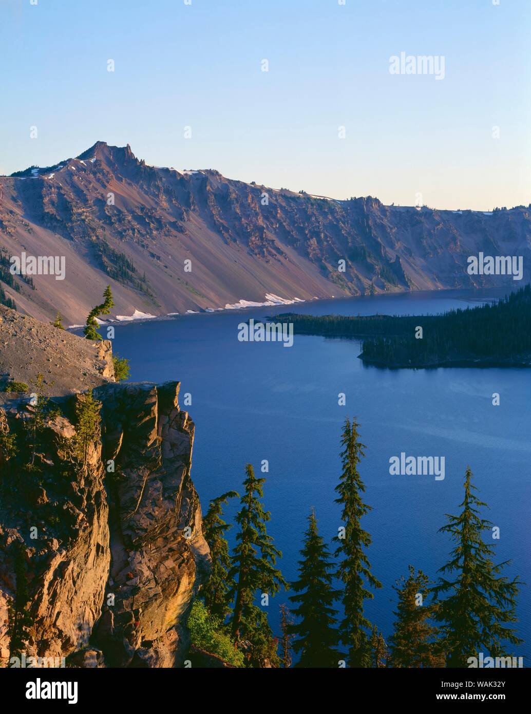USA, Oregon, Crater Lake National Park. Sonnenaufgang am westlichen Rand des Kraters See mit Hillman Peak (links) mit Blick auf den Wizard Island. Stockfoto