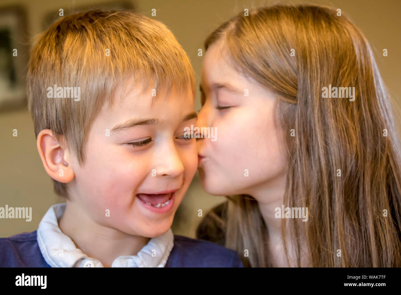 Neun Jahre altes Mädchen küsste ihre sieben Jahre alten Bruder auf seinem Geburtstag. (MR) Stockfoto