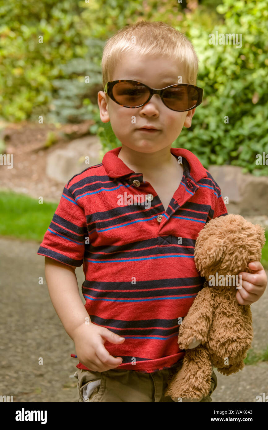Issaquah, Washington State, USA. Zwei Jahre alter Junge mit Teddybär und tragen Sonnenbrillen. (MR) Stockfoto