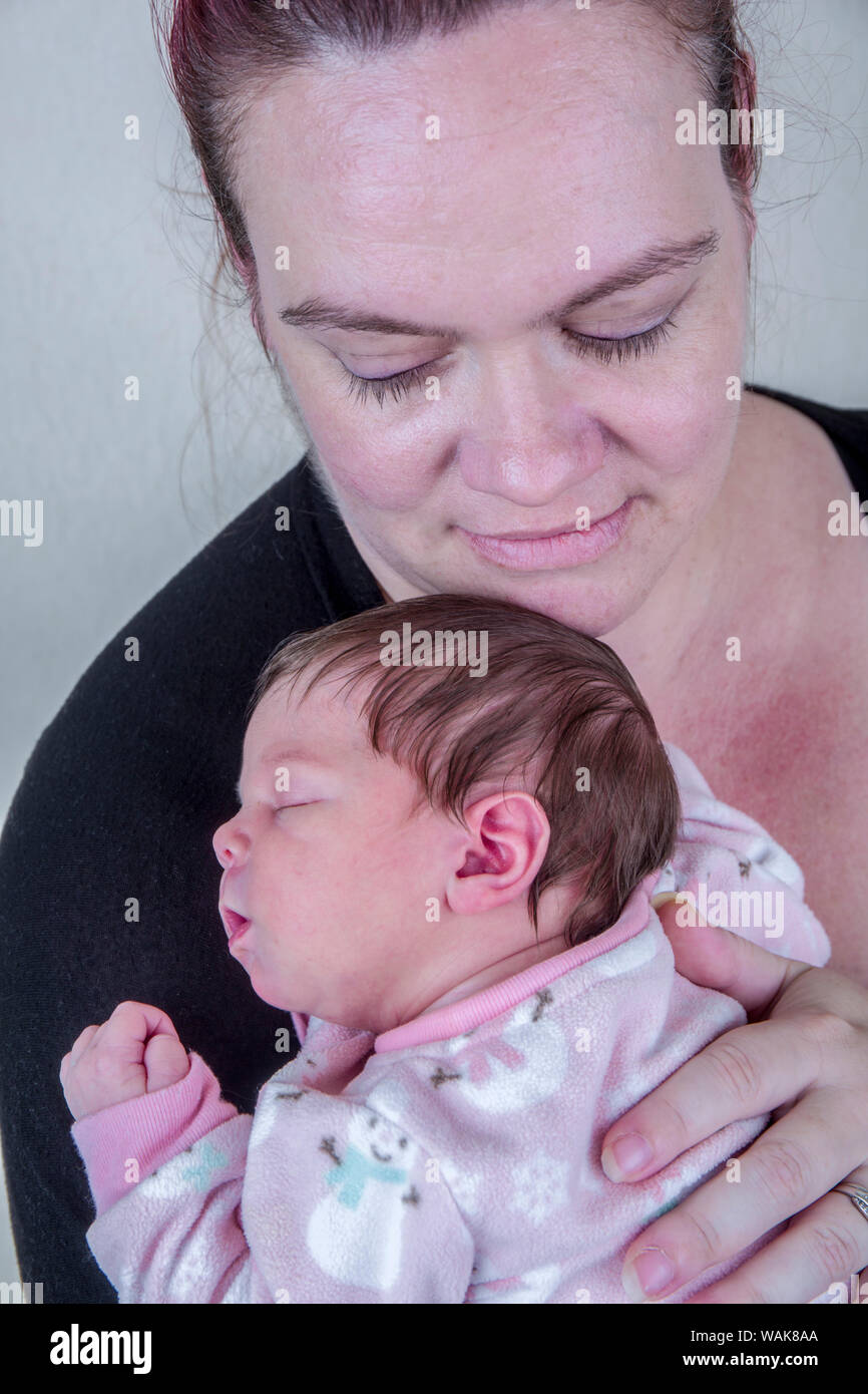 Mutter zärtlich Holding ihren schlafenden zwölf Tage altes Baby. (MR) Stockfoto