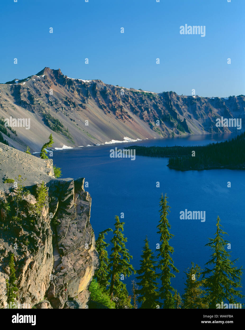 USA, Oregon. Crater Lake National Park, morgen am Westrand der Kratersee mit Hillman Peak (links) mit Blick auf den Wizard Island. Stockfoto