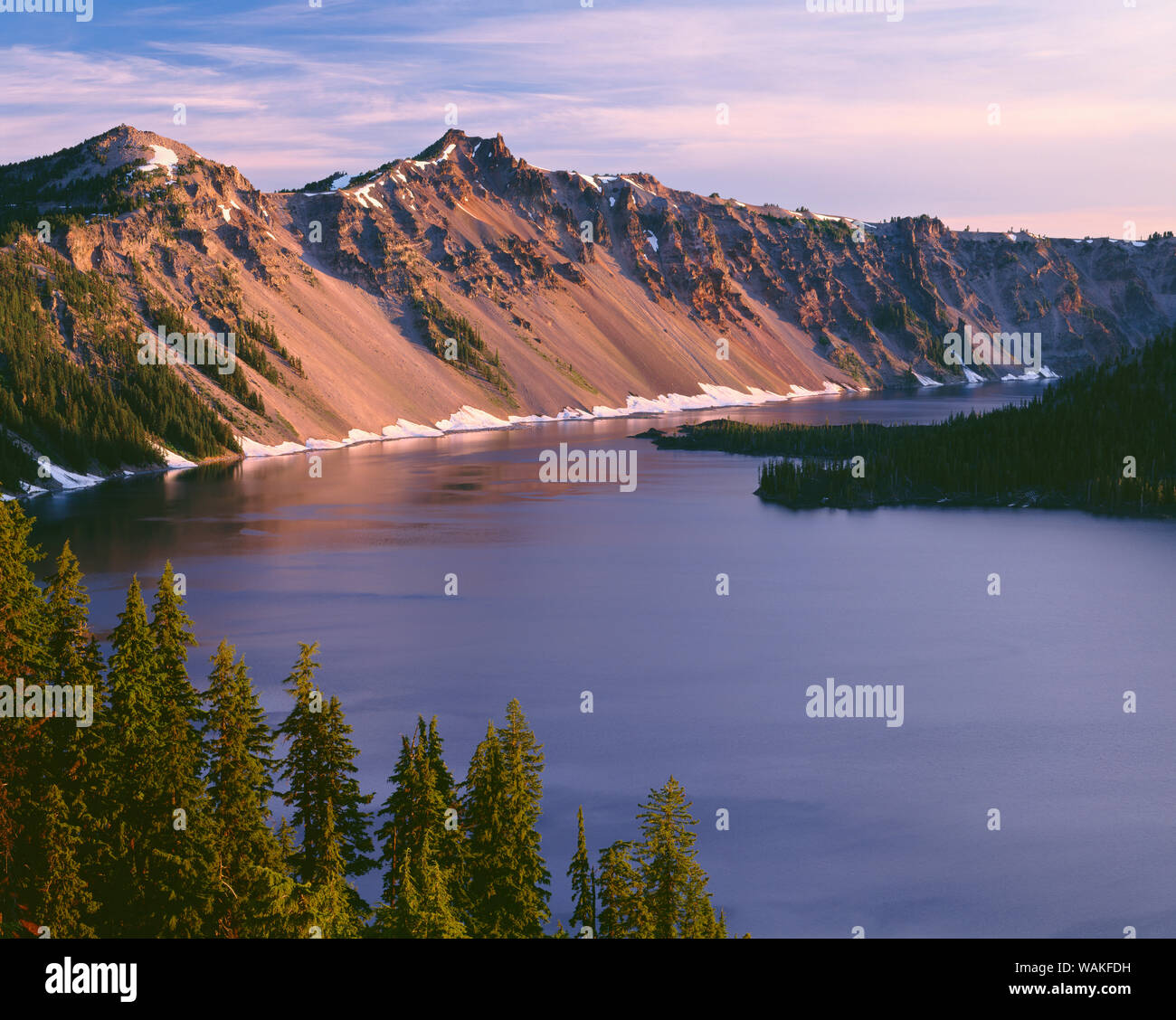 USA, Oregon. Crater Lake National Park, Sonnenaufgang am westlichen Rand der Crater Lake mit der Wächter (links) und Hillman Peak (Mitte) mit Blick auf den Wizard Island. Stockfoto