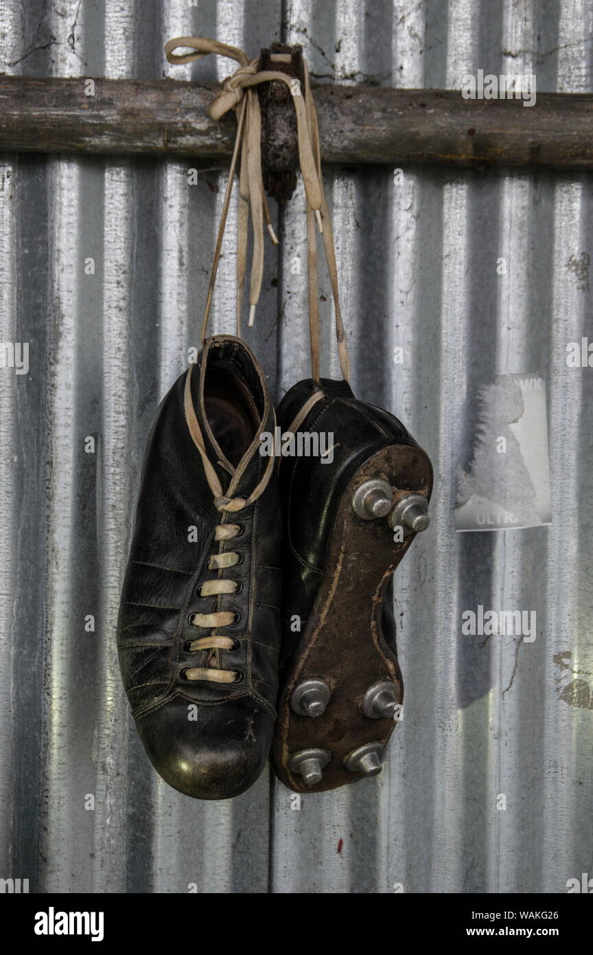 Antik leder Fußballbügelen, Vintage, vintage Stiefel Leder Fußballschuhe  hingen vor einem Wellpappe Zinn Zaun Stockfotografie - Alamy
