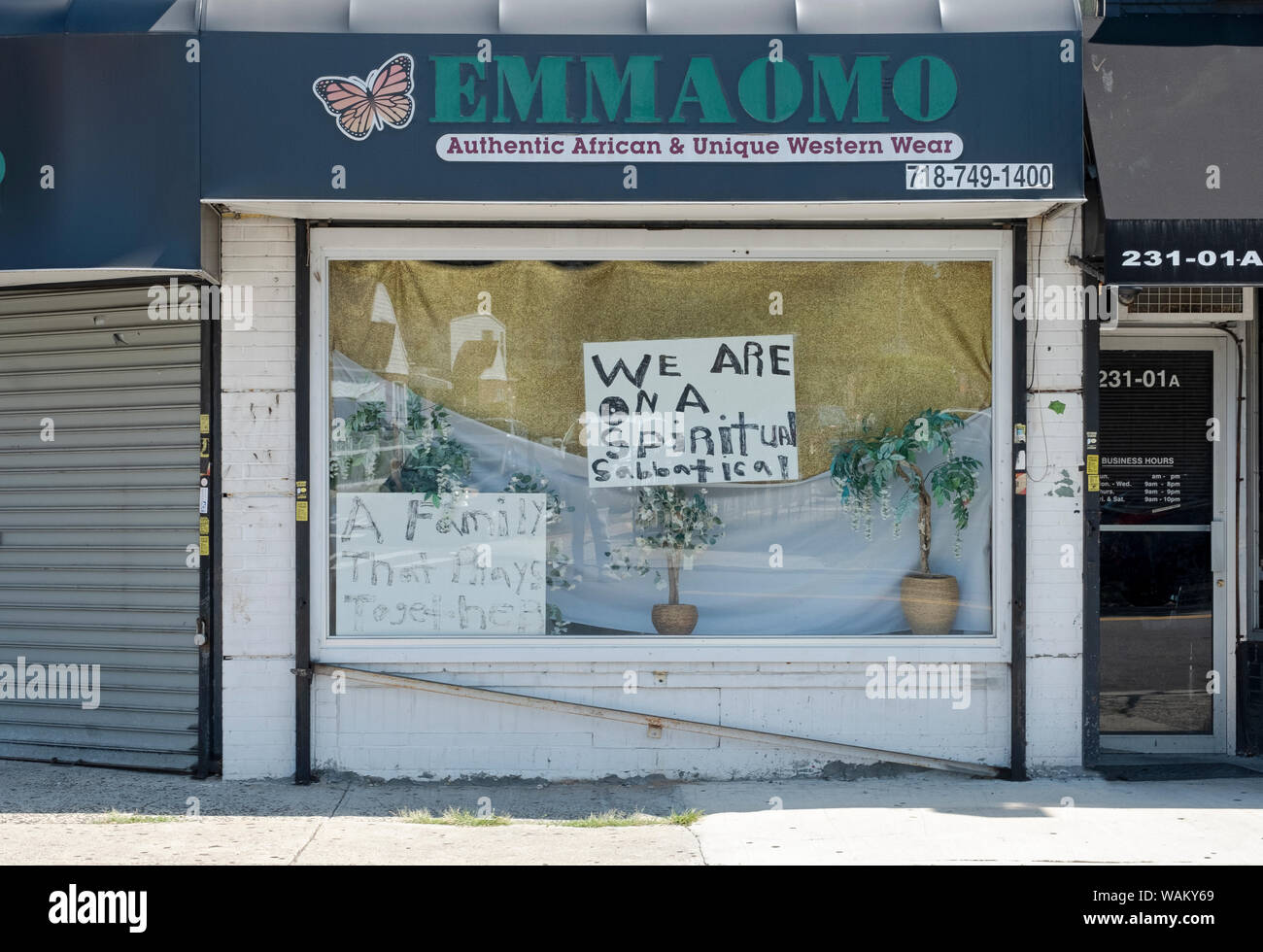 Eine ungewöhnliche Zeichen im Fenster des EMMAOMO, Fashion Store auf Linden Blvd. in Cambria Heights, Queens, New York City. Stockfoto