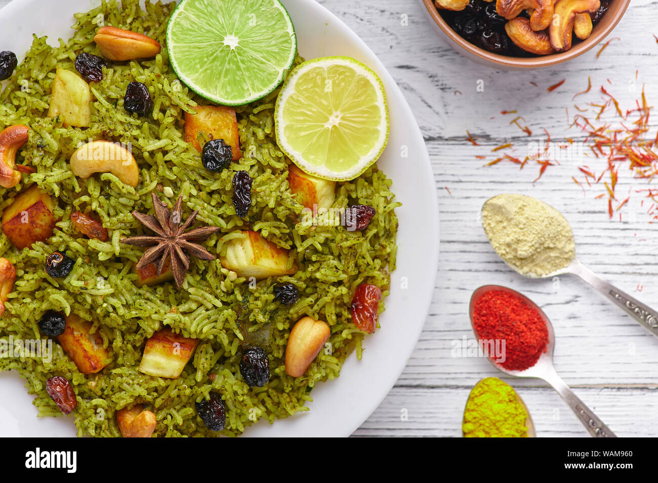 Palak Paneer Biryani und Raita im Hintergrund mit weißen Holzmöbeln eingerichtet. Palak Paneer Biryani ist vegetarische indische Küche Teller mit Spinat, paneer Chee Stockfoto