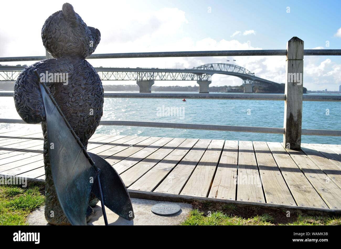 Teddybär Statue zur Erinnerung an Lawrence D Nathan (1910-1987) an der Westhaven Marina, mit Blick auf die Auckland Harbour Bridge Stockfoto