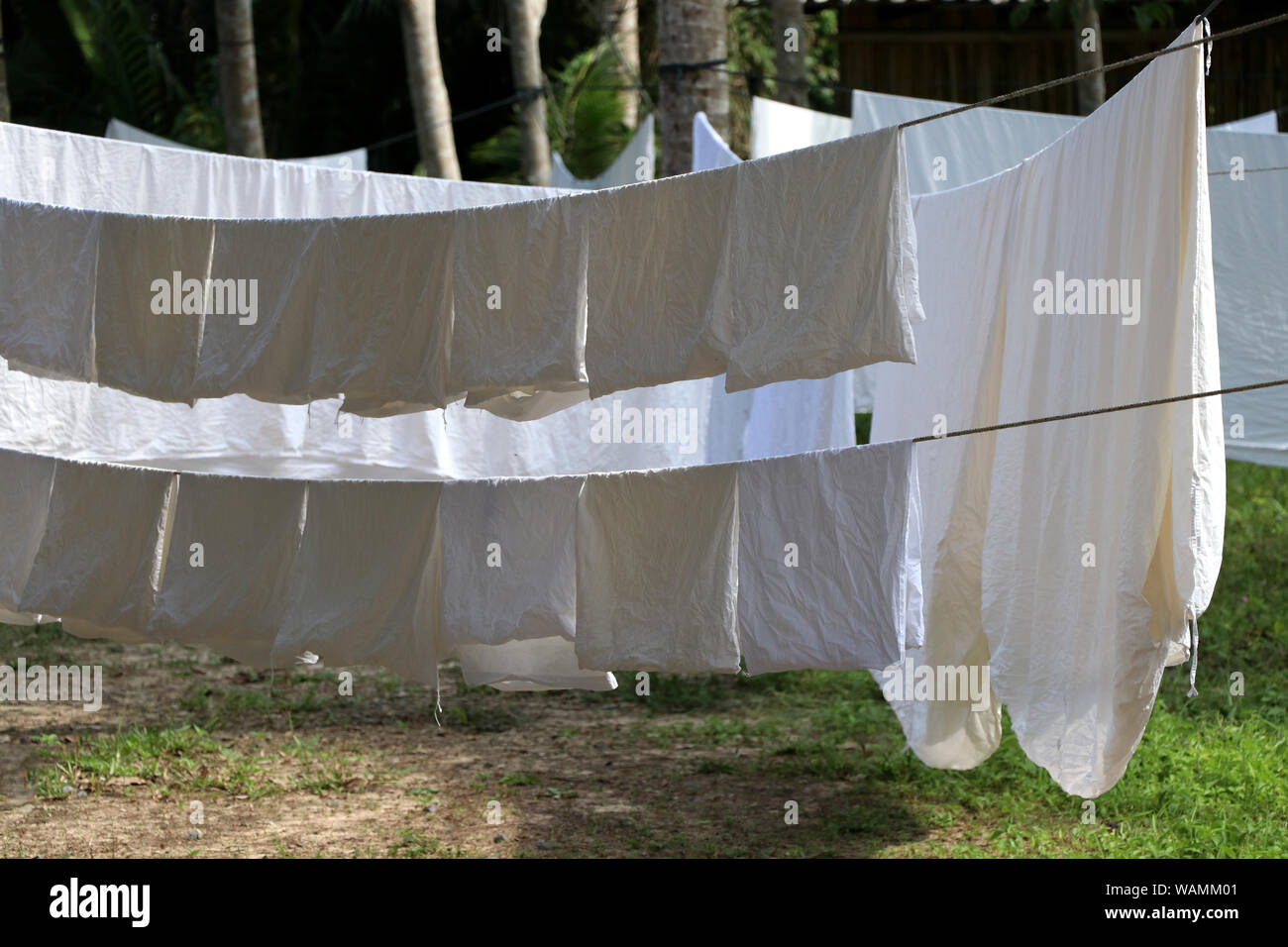 Das weiße Tuch ist, die Sonne auf der Wäscheleine ausgesetzt. Ein großes weißes Tuch auf eine Wäscheleine gehängt. Stockfoto