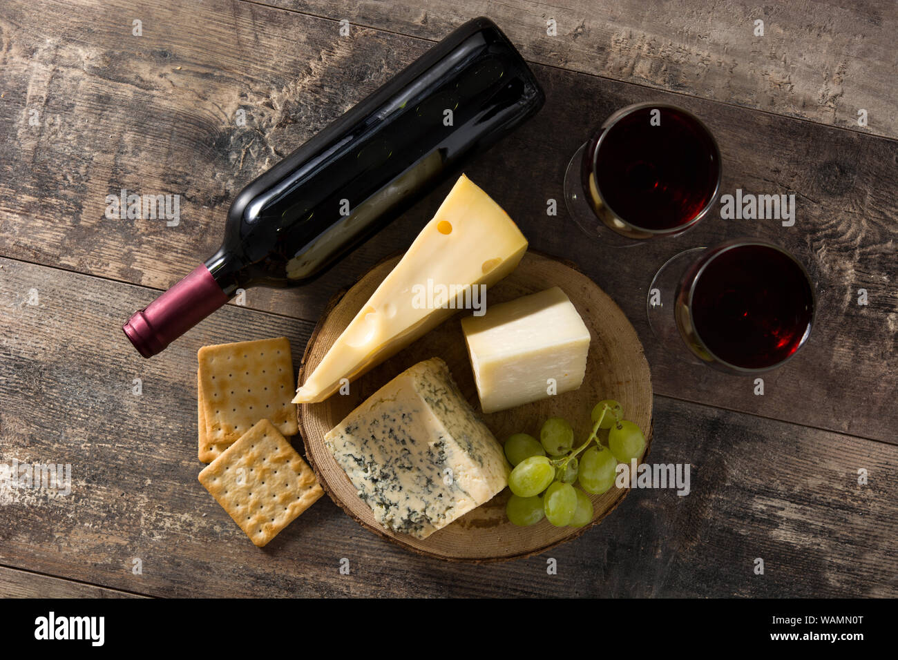 Auswahl an Käse und Wein auf hölzernen Tisch. Ansicht von oben. Stockfoto