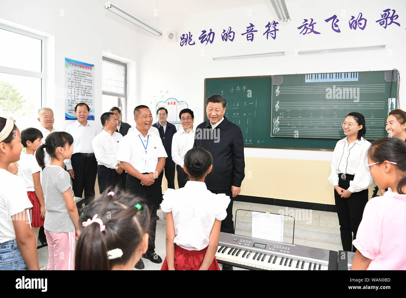 Wuwei, Provinz Gansu in China. 21 Aug, 2019. Der chinesische Präsident Xi Jinping, auch Generalsekretär der Kommunistischen Partei Chinas und Vorsitzender der Zentralen Militärkommission, besuche eine neue Gemeinschaft, die Heimat der ländlichen Bewohner aus ökologischen Bedenken verlegt, und fragt die Dorfbewohner über ihren Lebensunterhalt und die Fortschritte bei der Linderung von Armut, fumin neue Dorf Gulang County, Wuwei Stadt im Nordwesten der chinesischen Provinz Gansu, Aug 21., 2019. Credit: Xie Huanchi/Xinhua/Alamy leben Nachrichten Stockfoto