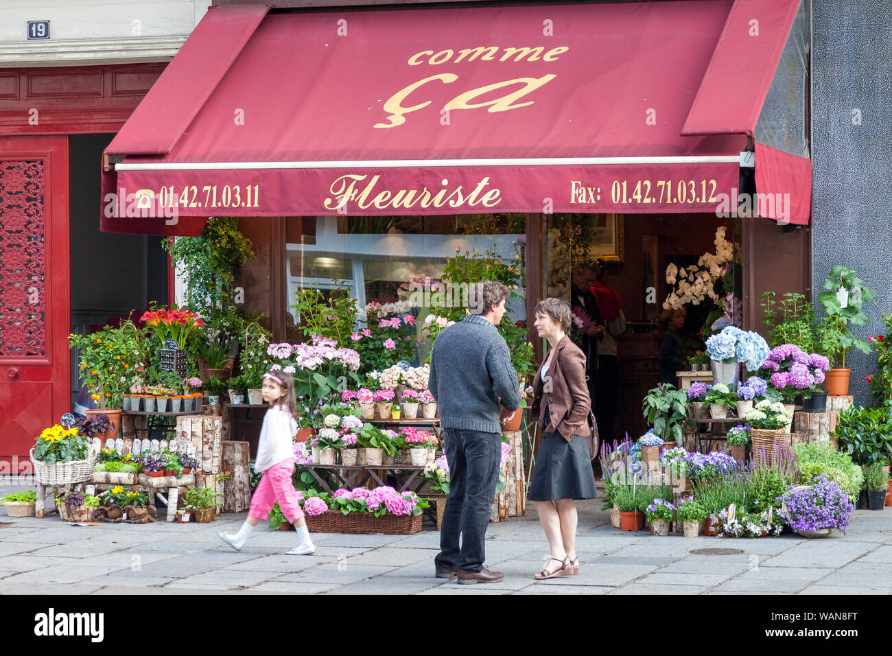 Mann und Frau im Gespräch außerhalb einer Flower Shop im Marais, Paris, Frankreich Stockfoto