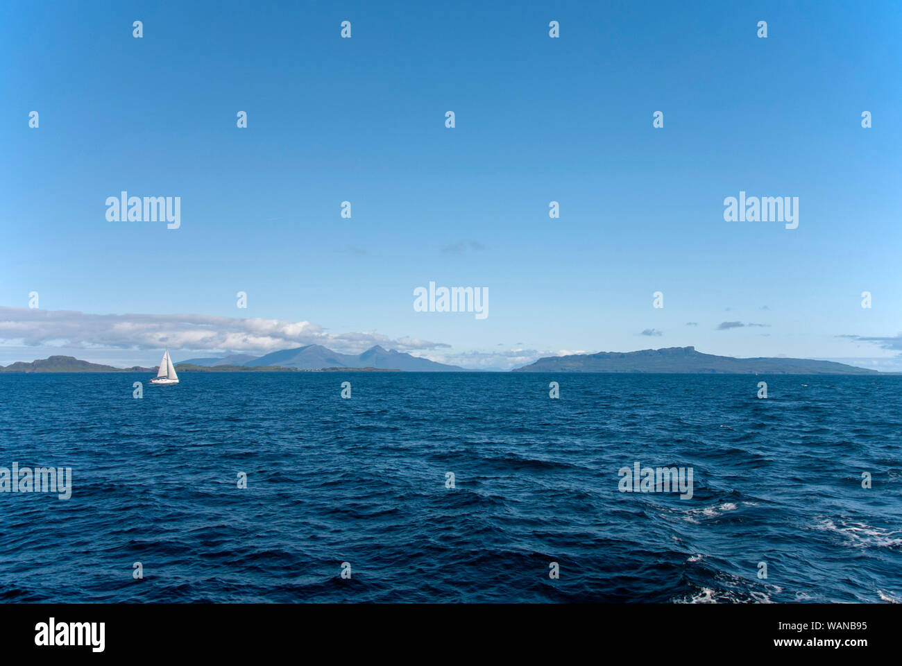 Weiße Yacht mit abgelegenen schottischen Inseln Eigg und Muck, Rum Stockfoto