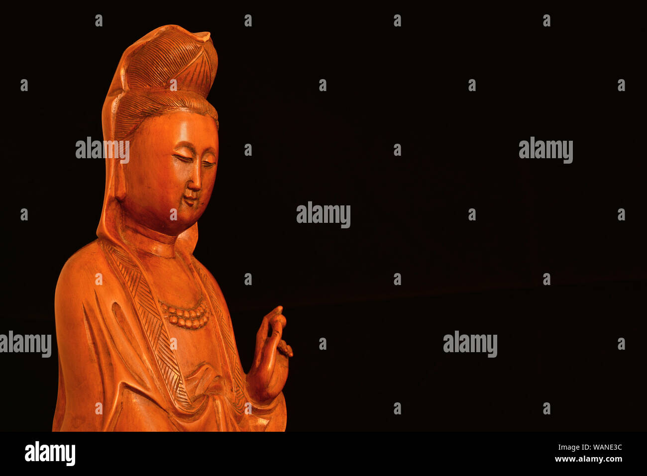 Buddhistische Religion und Meditation. Kannon oder Guanyin, der Göttin der Barmherzigkeit, Holz- statuette auf schwarzem Hintergrund (mit Kopie Raum) Stockfoto