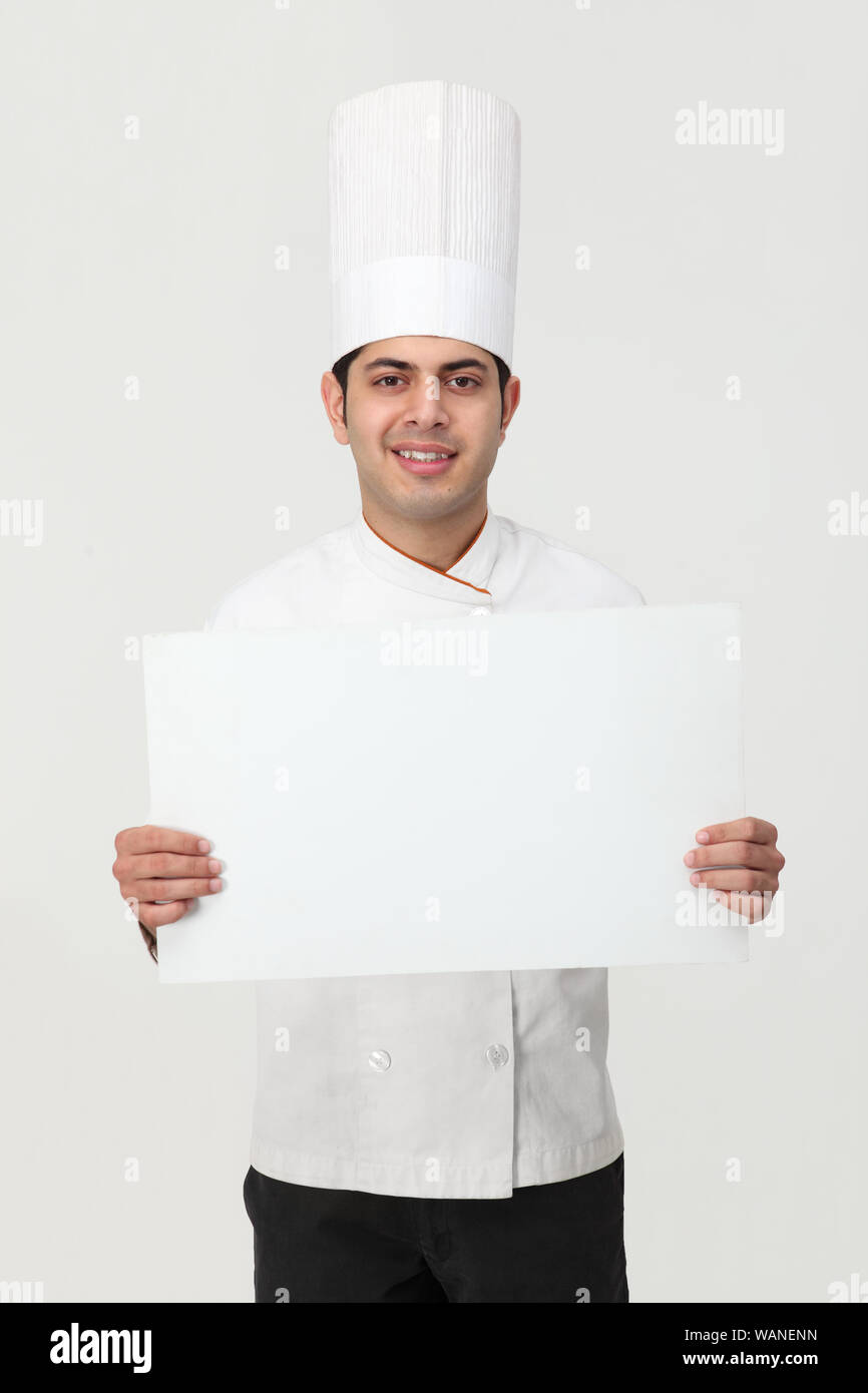 Indischer Koch zeigt ein leeres Plakat Stockfoto