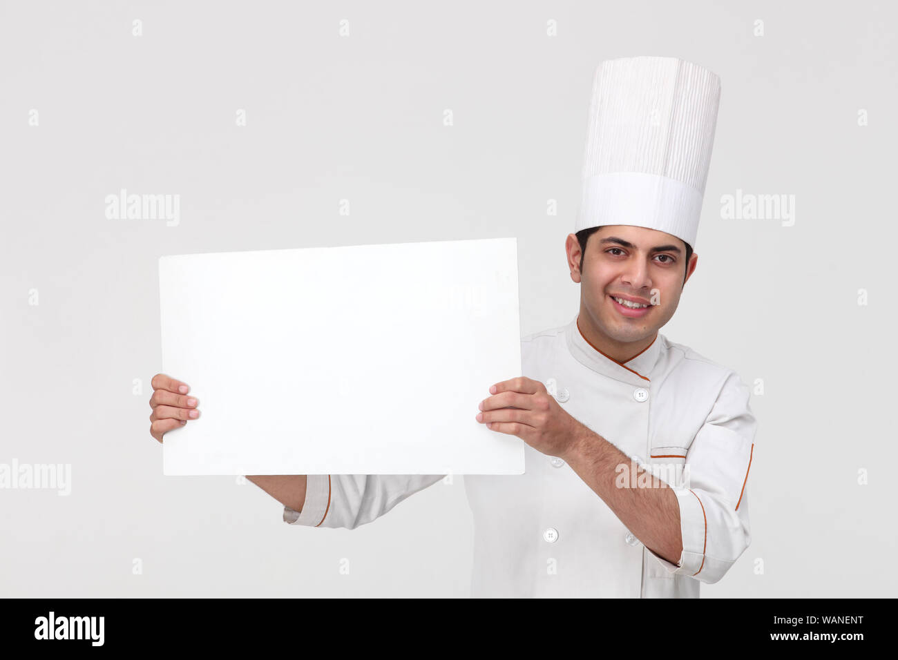 Indischer Koch zeigt ein leeres Plakat Stockfoto