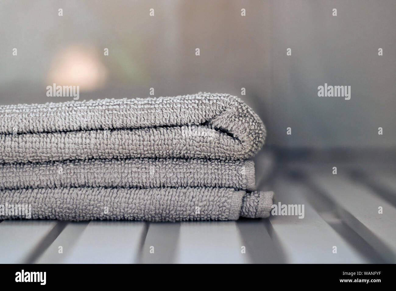 Graue Handtücher auf einem Tisch im Badezimmer. Stockfoto
