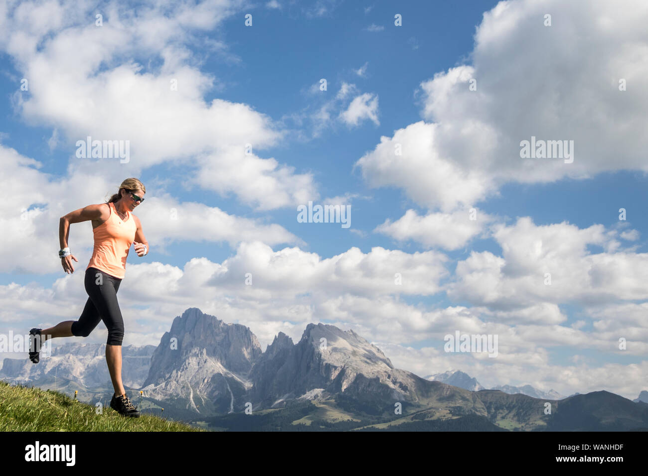 Eine Frau Trail Runner Gebühren vor der Dolomiten Bergwelt Stockfoto