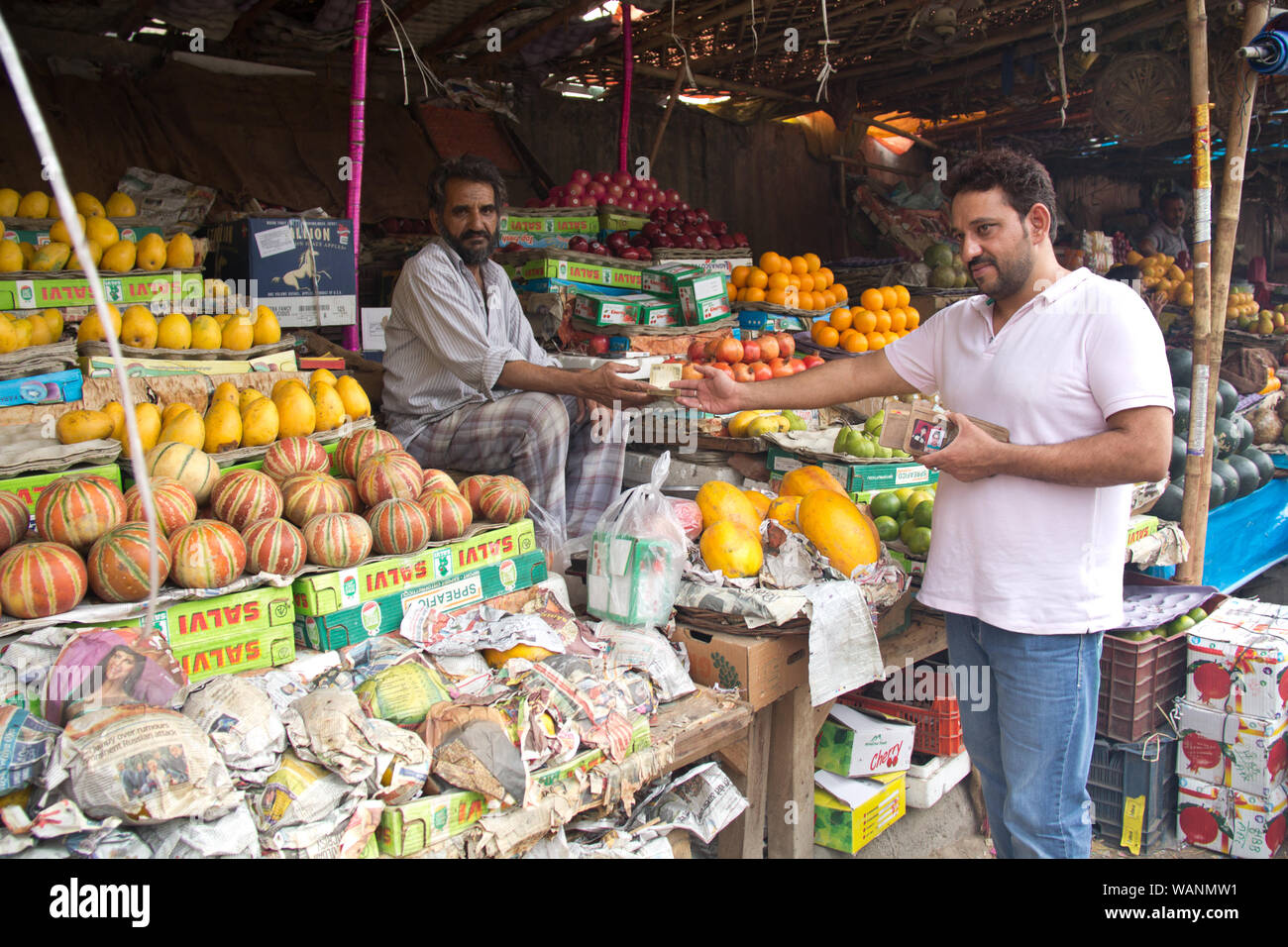 Kunde zahlt Geld an einen Ladenbesitzer an einem Marktstand, Gurgaon, Haryana, Indien Stockfoto