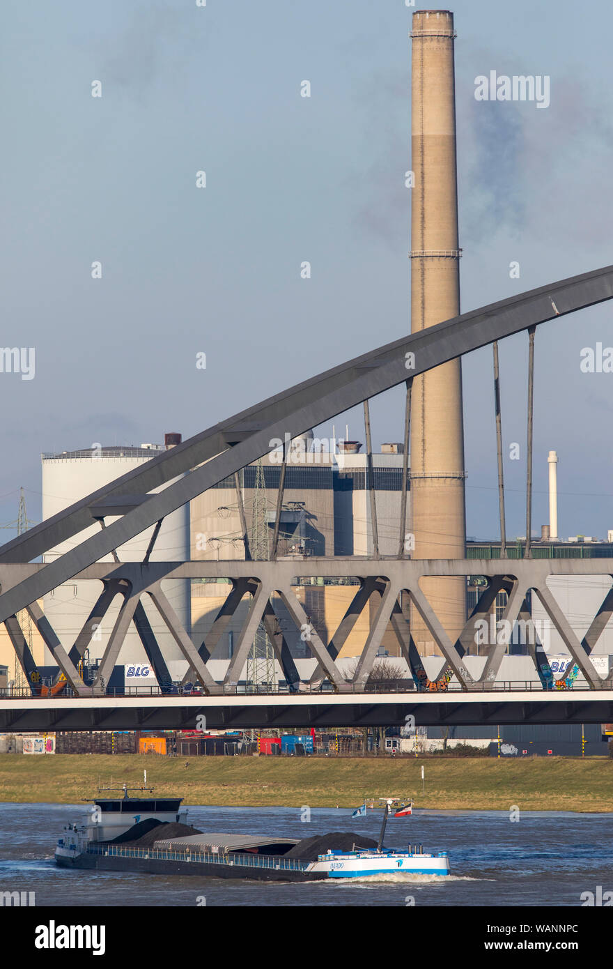 Frachtschiff auf dem Rhein in der Nähe von Düsseldorf, Regionalbahn, S-Bahn Brücke in der Nähe von Düsseldorf-Hamm, Kraftwerk Lausward Stockfoto