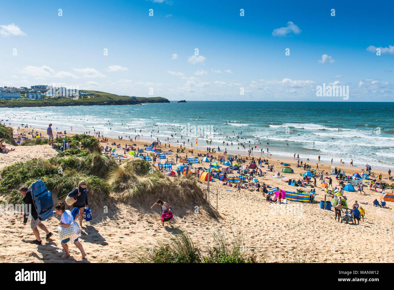 Urlauber auf einem Aufenthalt Urlaub an einem sonnigen Fistral Beach in Newquay in Cornwall. Stockfoto