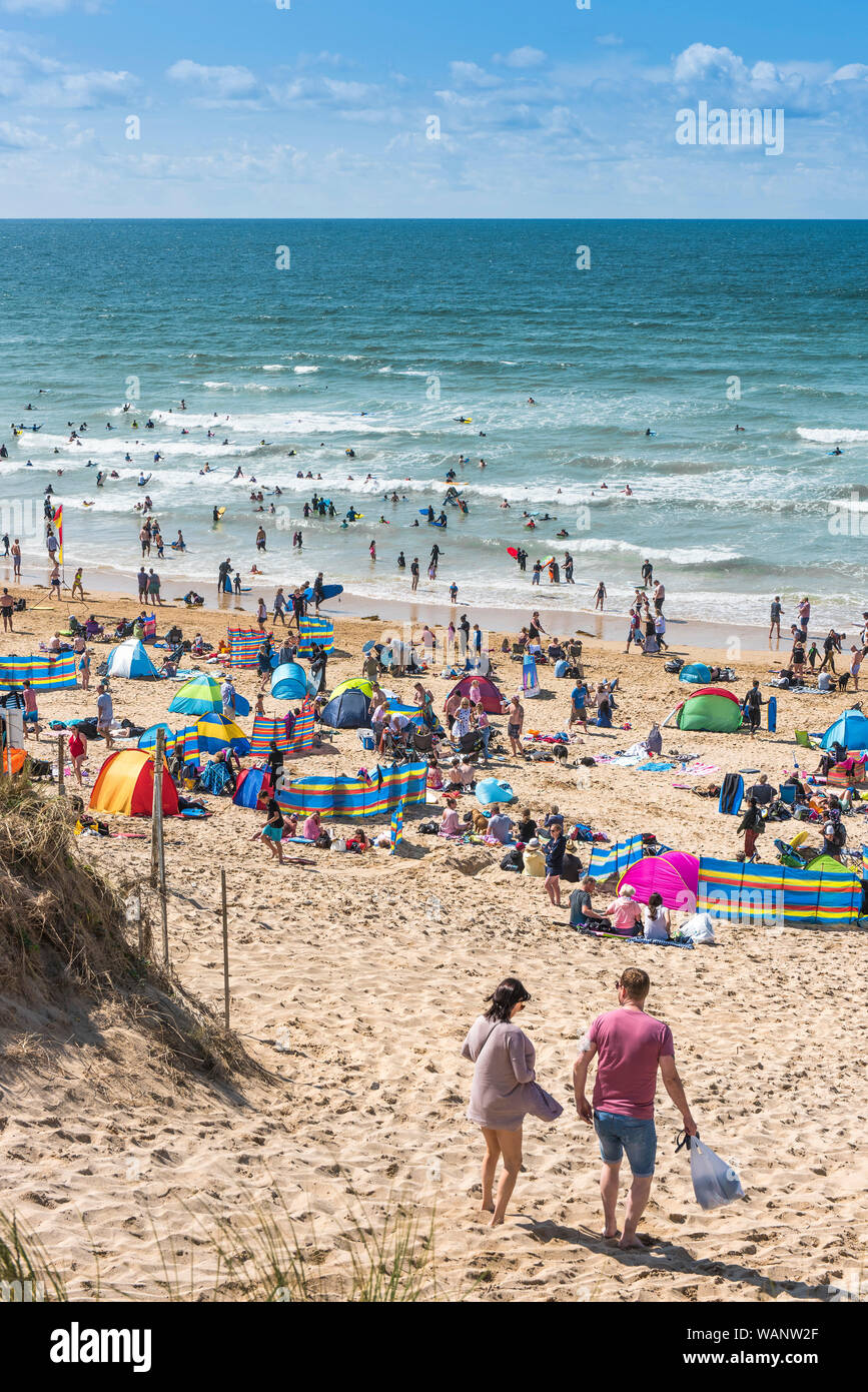 Urlauber auf einem sonnigen Fistral Beach in Newquay in Cornwall. Stockfoto