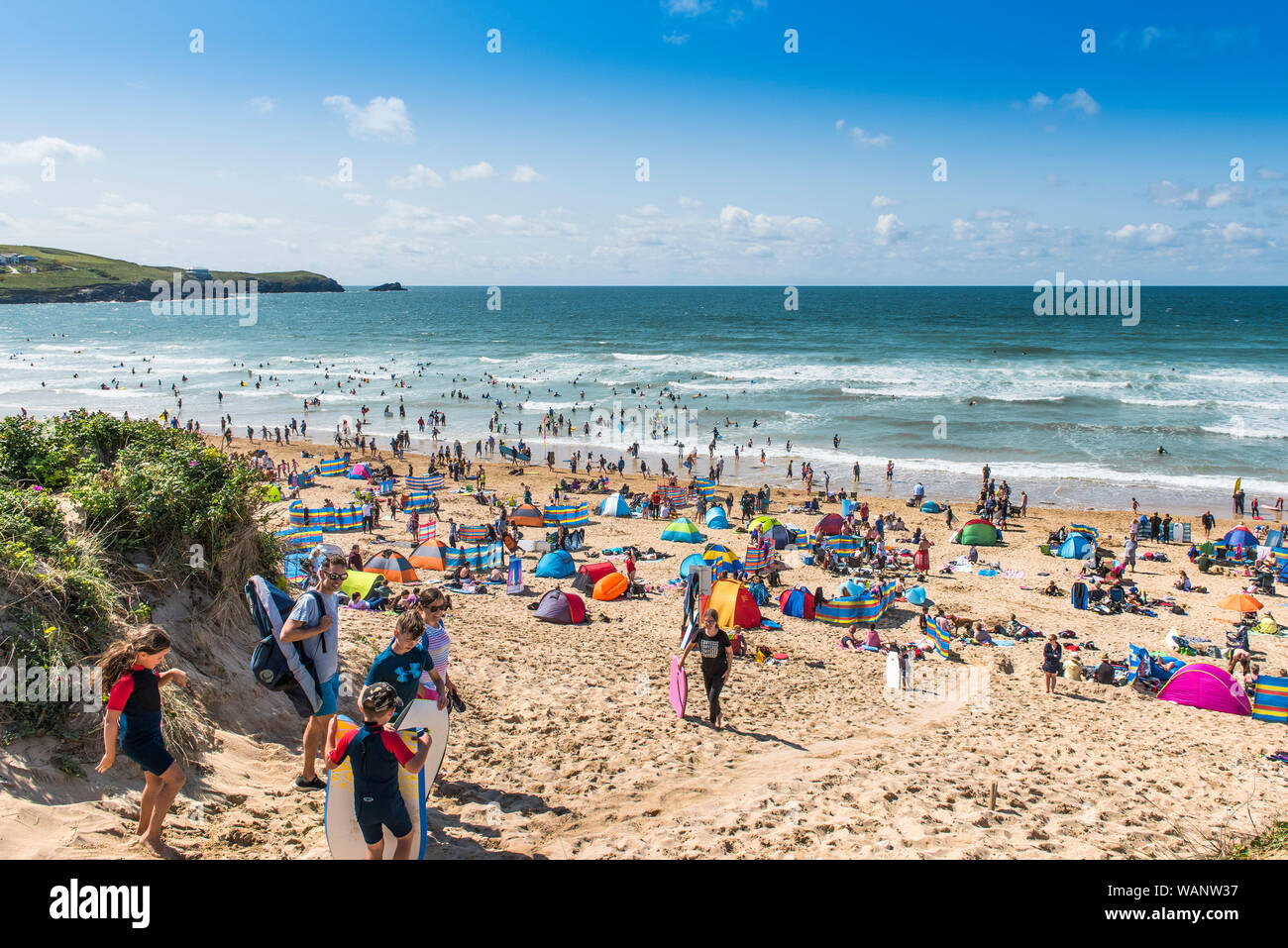 Urlauber, die sich auf einen Aufenthalturlaub am sonnigen Fistral Beach in Newquay in Cornwall freuen. Stockfoto