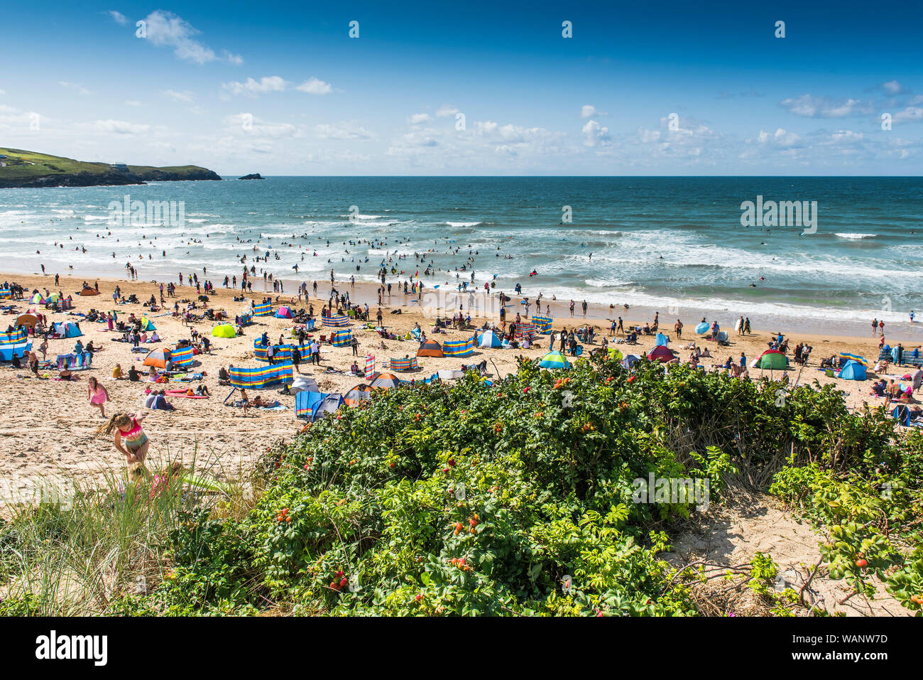 Urlauber auf einem Aufenthalt Urlaub an einem sonnigen Fistral Beach in Newquay in Cornwall. Stockfoto