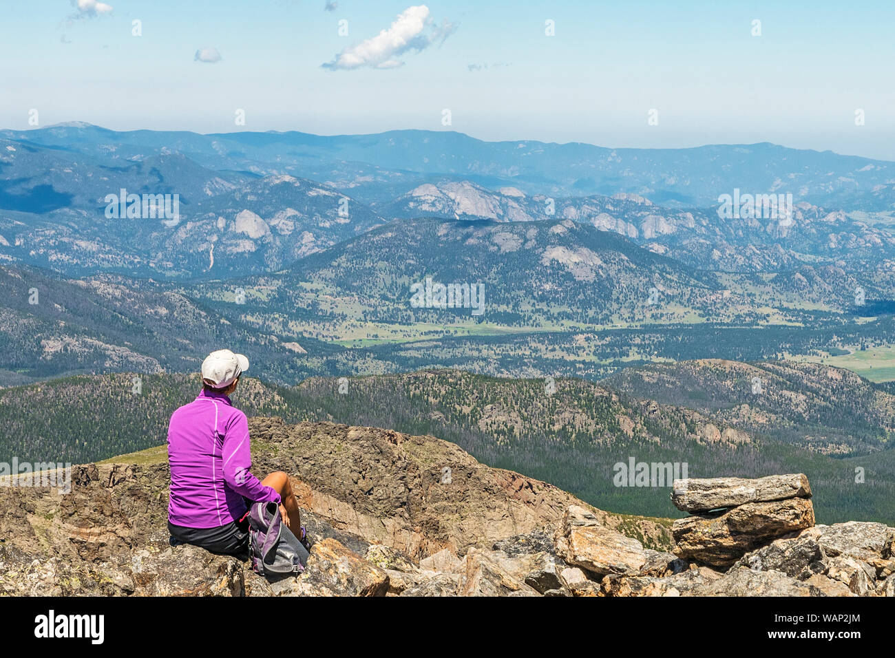 Eine weibliche Wanderer mit Blick auf die westlichen Täler der Rocky Mountain National Park, während Sie entlang der Flattop Mountain Trail. Stockfoto