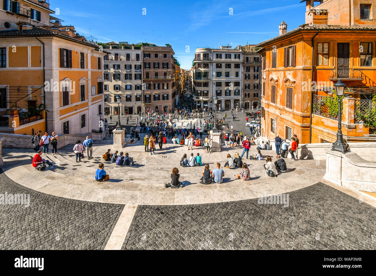 Blick auf die Via Condotti von der Spanischen Treppe unter der Trinita dei Monti von Touristen sitzen auf der Treppe, Entspannen und Genießen die Piazza di Spagna Stockfoto