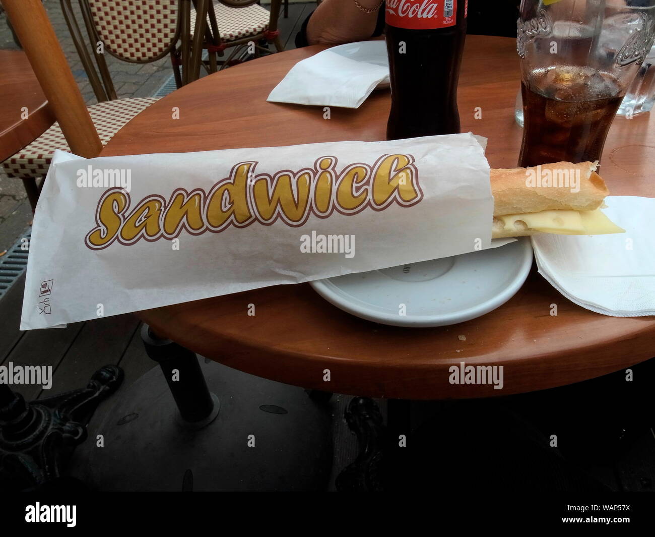 AJAXNETPHOTO. 2018. VILLE D'AVRAY, Frankreich. - BAGUETTE KÄSE SANDWICH IN PAPIERTÜTE AUF EINEM TISCH MIT PLATTEN UND TRINKEN EIN GLAS. Foto: Jonathan Eastland/AJAX REF: GR 182211 8475 Stockfoto