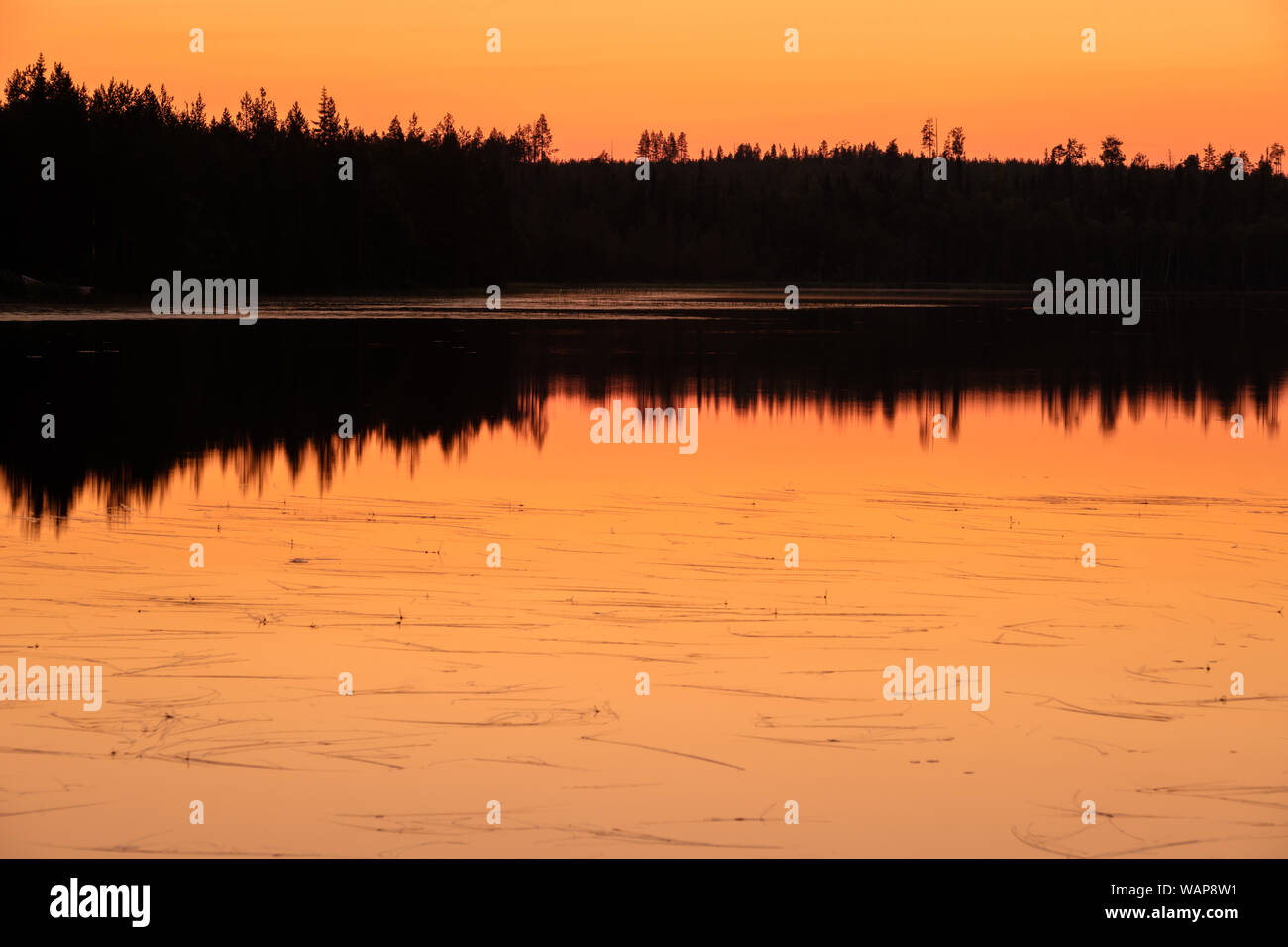 Intensive Sonnenuntergang über dem See in Finnland mit schönen Reflexionen Stockfoto