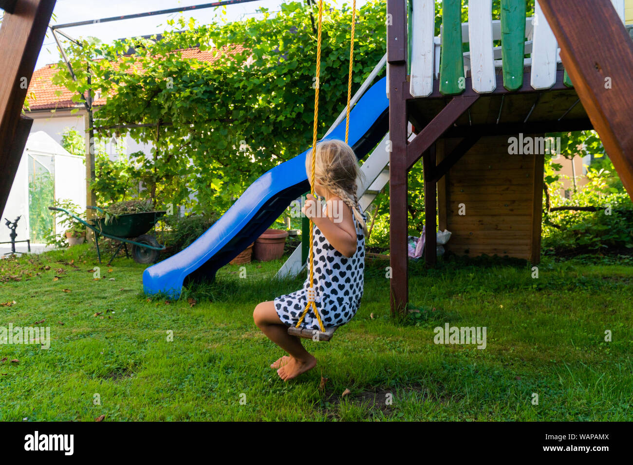 3-5 jährige blonde Mädchen Spaß haben auf einer Schaukel im Freien. Sommer Spielplatz. Mädchen Schwingen hoch. Junge Kind auf der Schaukel im Garten Stockfoto