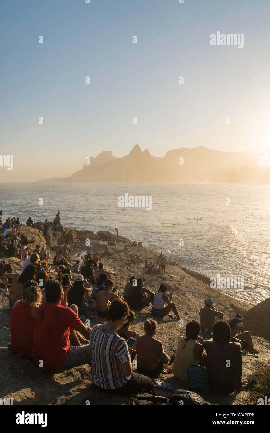 Menschenmassen versammelt, um den Sonnenuntergang von Arpoador Rock, Rio de Janeiro zu sehen Stockfoto
