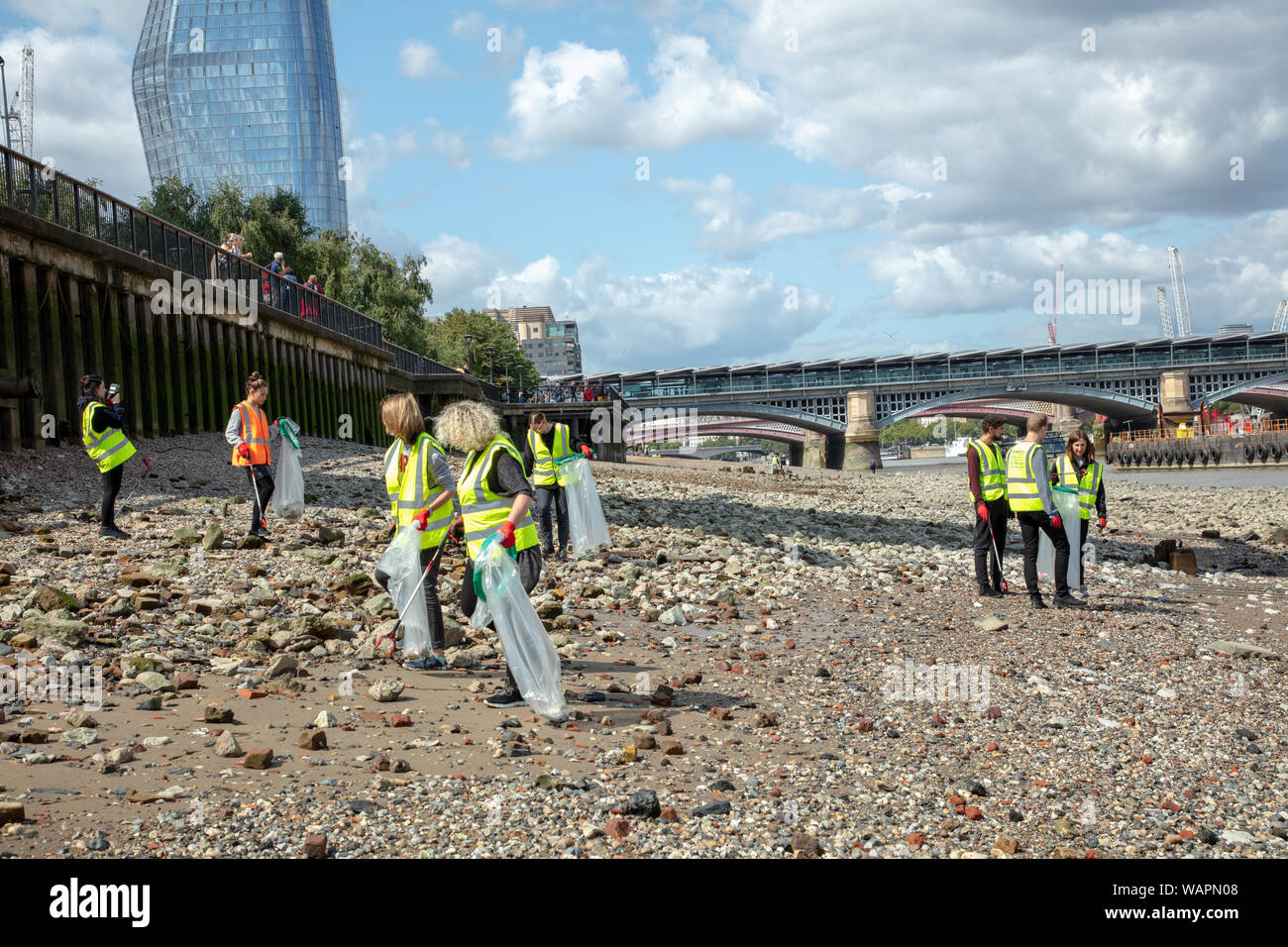 London, Großbritannien. 20. August 2019. Freiwillige, durch Bywaters Recycling und Abfallwirtschaft Anbieter organisiert, Reinigung der Strand vor der Tate Modern aus Kunststoff und andere Abfälle bei Ebbe. Credit: Joe Kuis/Alamy Nachrichten Stockfoto