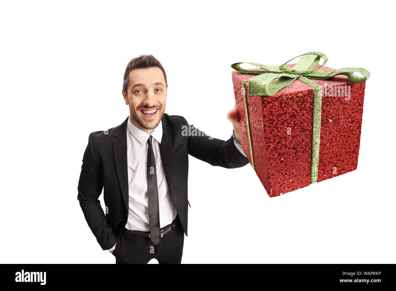 Junge elegante Mann im Anzug mit einem funkelnden Geschenkbox vor der Kamera auf weißem Hintergrund Stockfoto